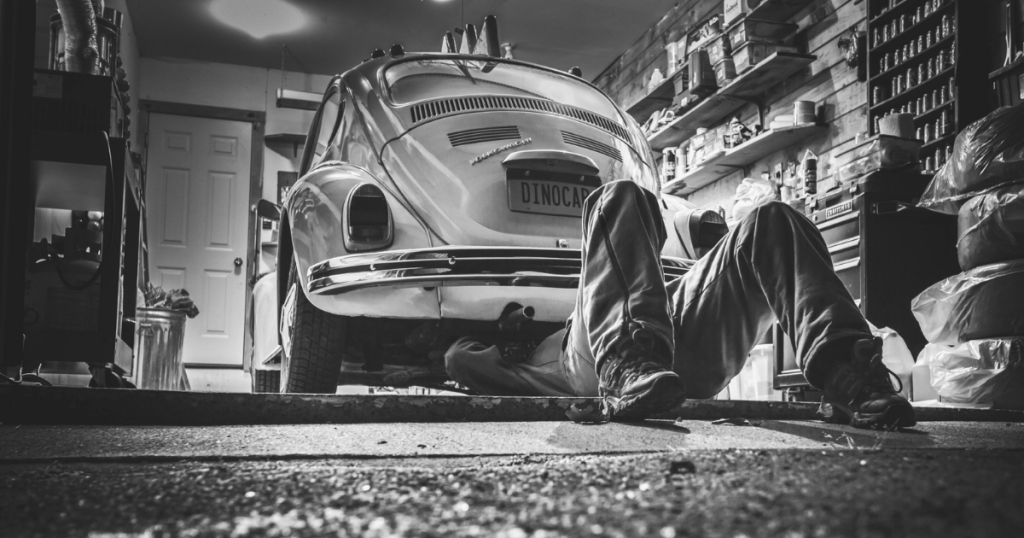 Mechanic lying under a car during a service in a workshop
